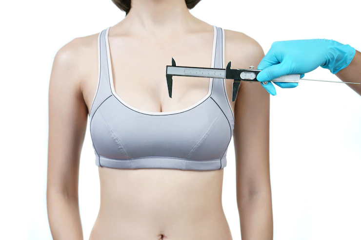 doctor hand measurement woman breast with caliper breast