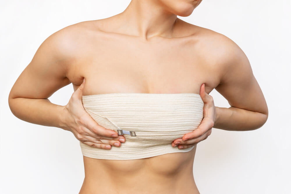 young woman wrapped elastic bandage after breast augmentation
